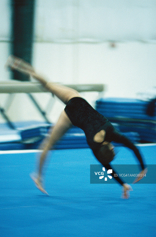女性体操运动员正在做侧手翻图片素材