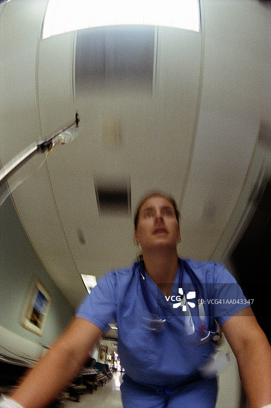 护士推着医用推车在医院走廊里行走（动态模糊）图片素材