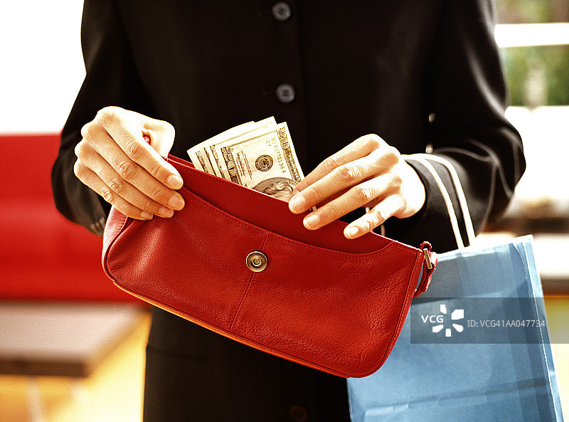女人从手提包里拿钱的近景图片素材