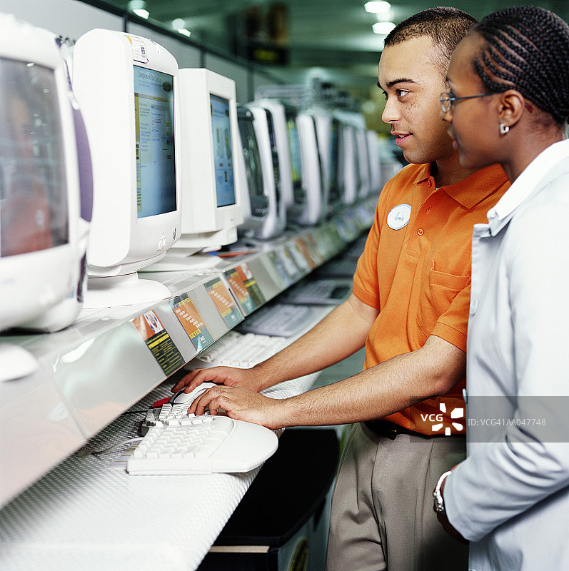 销售员在电脑商店协助女顾客图片素材