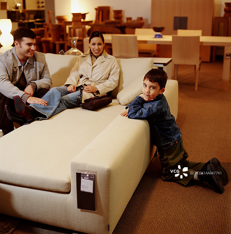 和父母一起购买沙发的男孩（4-6岁）图片素材
