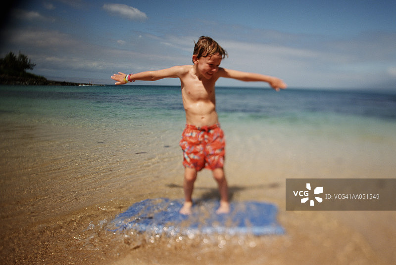 站在冲浪板上的男孩图片素材