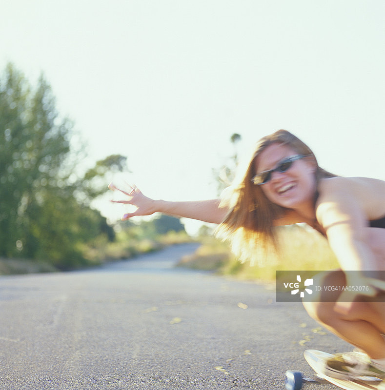 年轻女子蹲在长板上（柔焦）图片素材