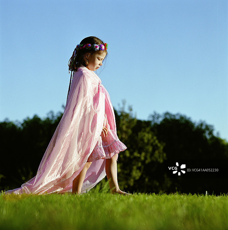 女孩 в розовом платье и накидке, смотрит вниз, вид сбоку图片素材