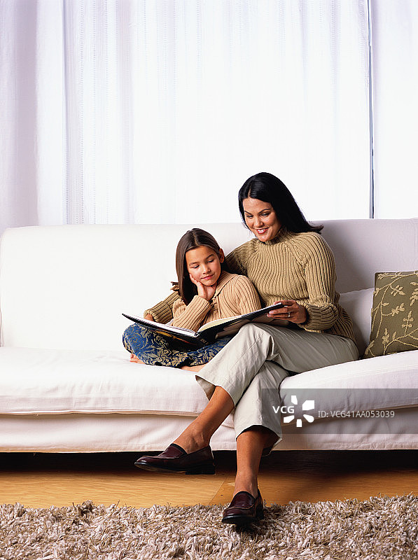 母女在沙发上一起看书图片素材
