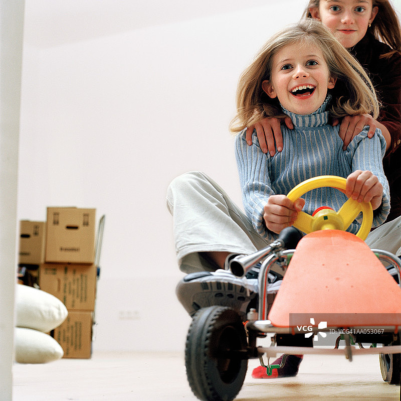 乘坐卡丁车的姐妹（7-11岁），低角度拍摄图片素材