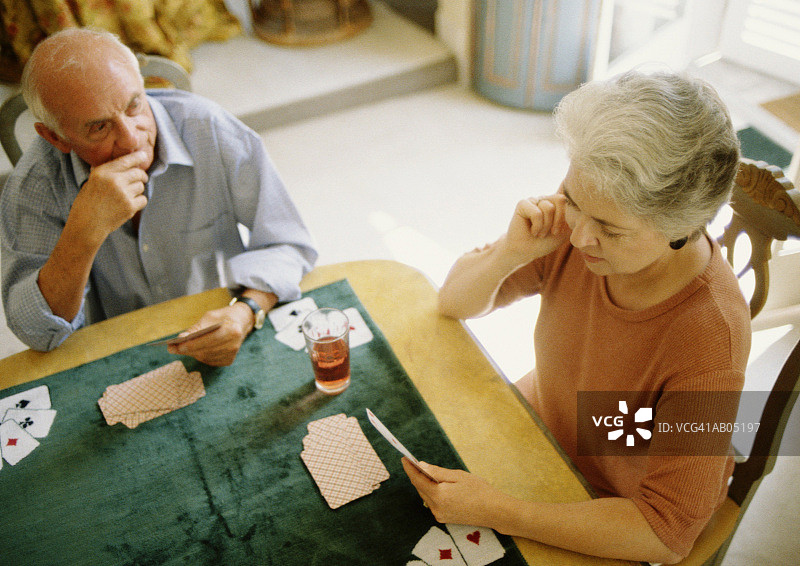 俯视中年夫妇在桌上玩牌图片素材