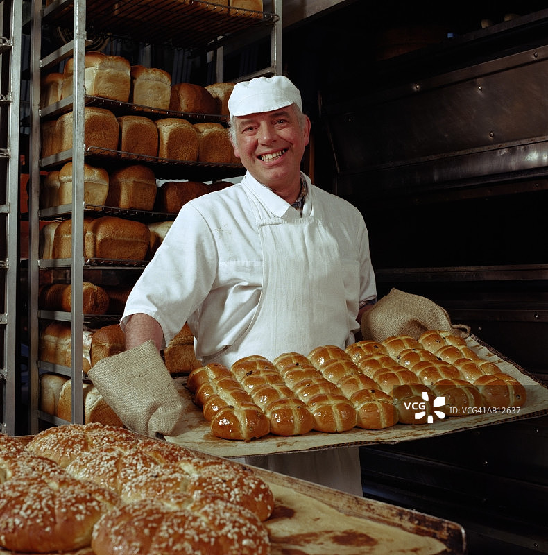 面包师拿着十字面包图片素材