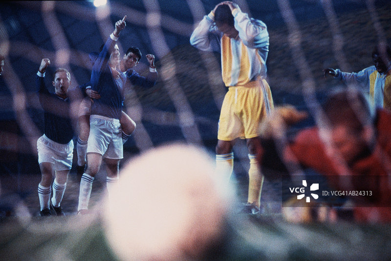 足球比赛：后卫与庆祝进球的对手图片素材