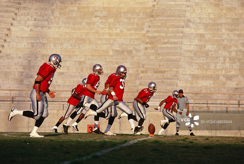 美式橄榄球运动员跑动踢球图片素材