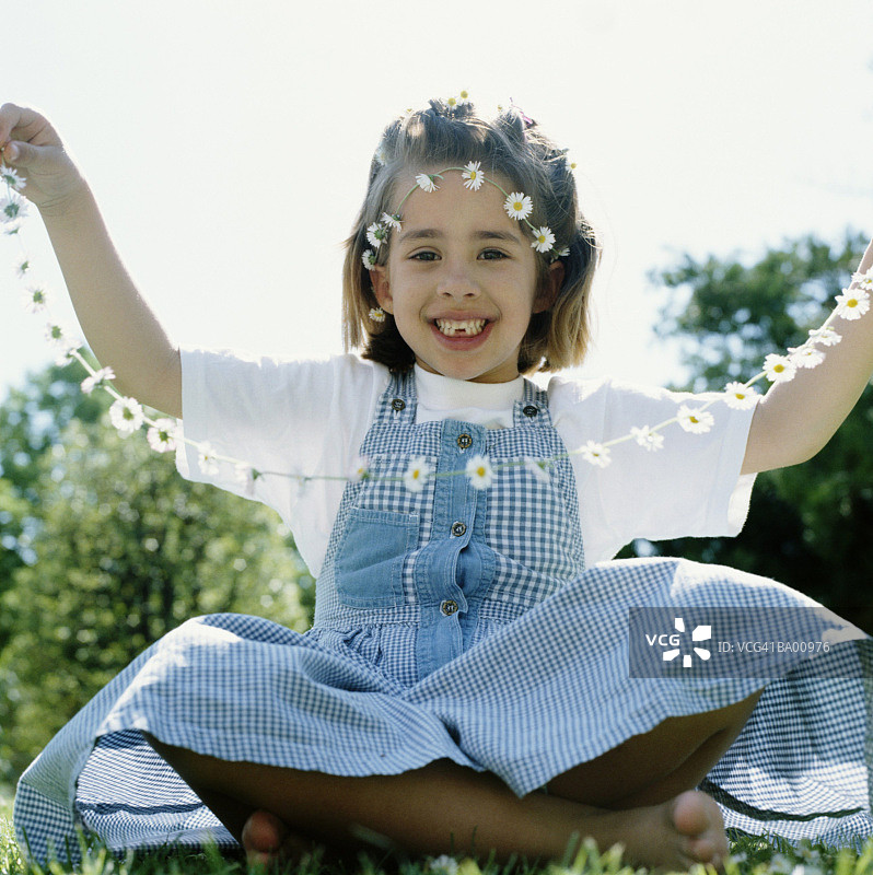 拿着雏菊花环的女孩（6-8岁）肖像图片素材