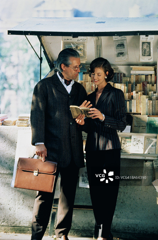 站在巴黎书摊旁的商务男人和女人图片素材