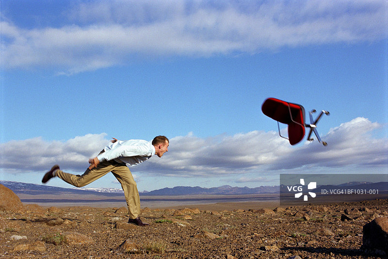 年轻男人将办公椅扔向空中（动态模糊）图片素材