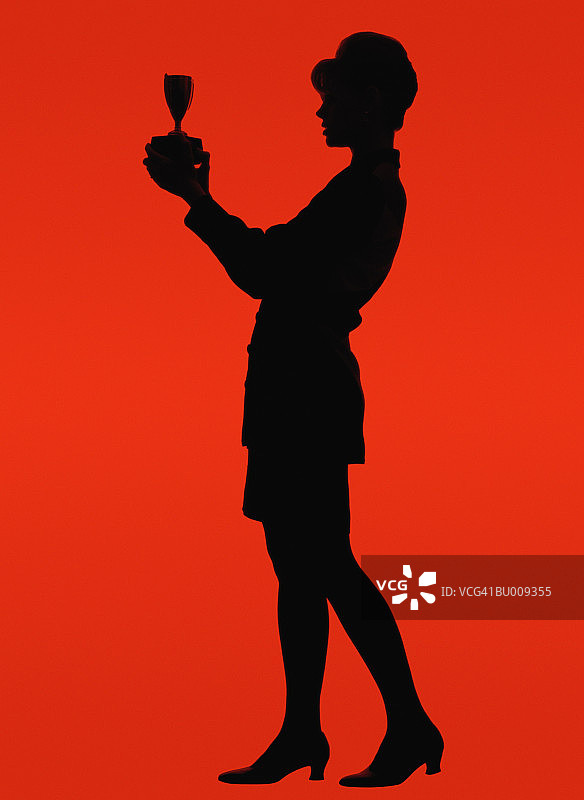 手持奖杯的商务女士剪影图片素材