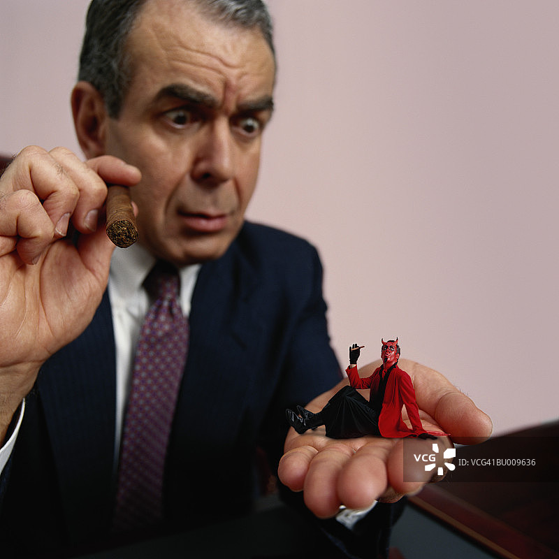 手拿恶魔模型的商人图片素材