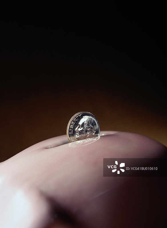 储蓄罐投币口的10美分硬币图片素材