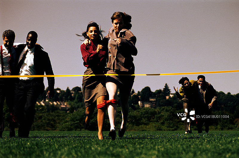 女商人在三人四足赛跑终点线图片素材