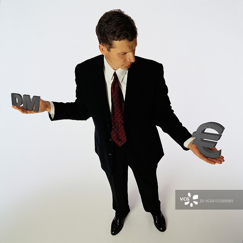 男人拿着德国马克和欧元标志图片素材