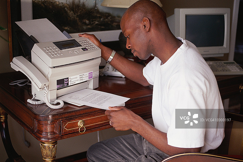 男人从传真机上取纸图片素材