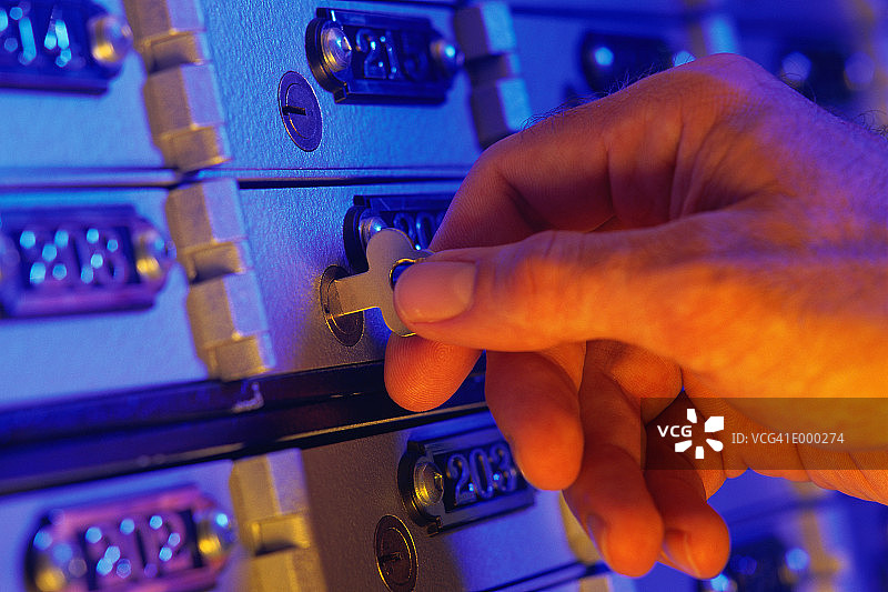 Рука открывает ключ от банковской ячейки图片素材