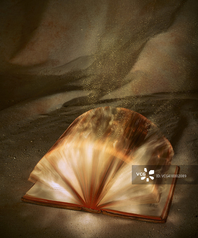 内部发光的打开的书本，书页快速翻动图片素材