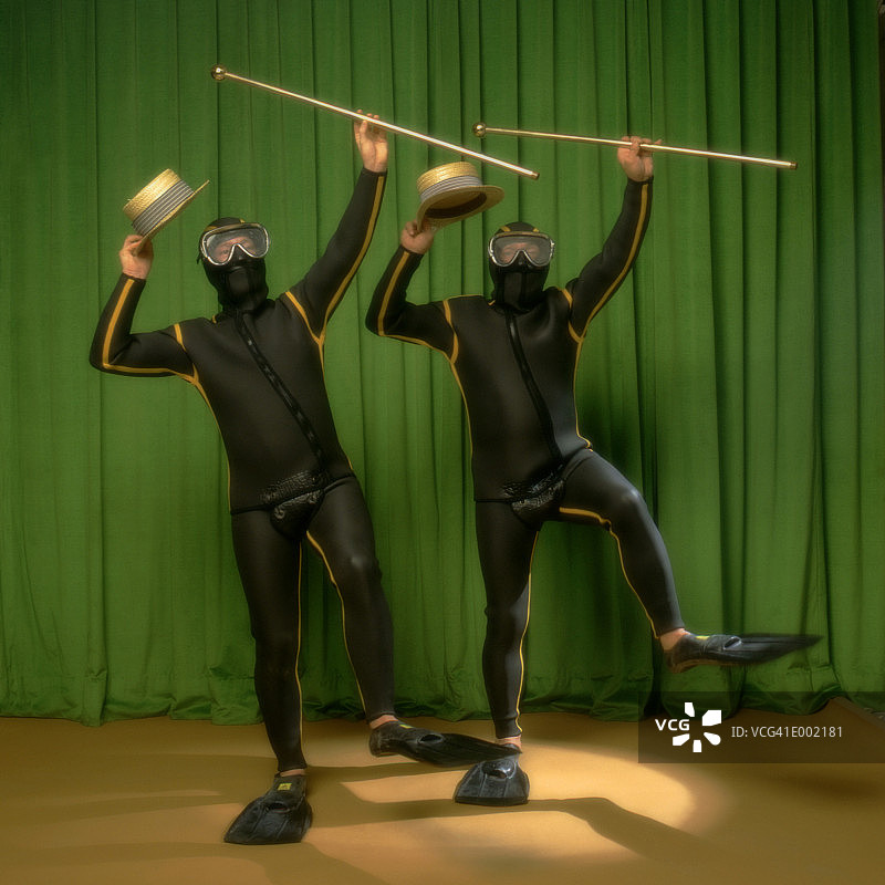 两个穿潜水服的男人拿着帽子和手杖在舞台上跳舞图片素材