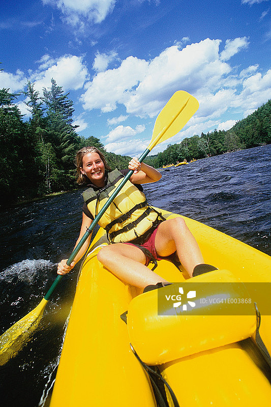 微笑的漂流者在河上划桨图片素材