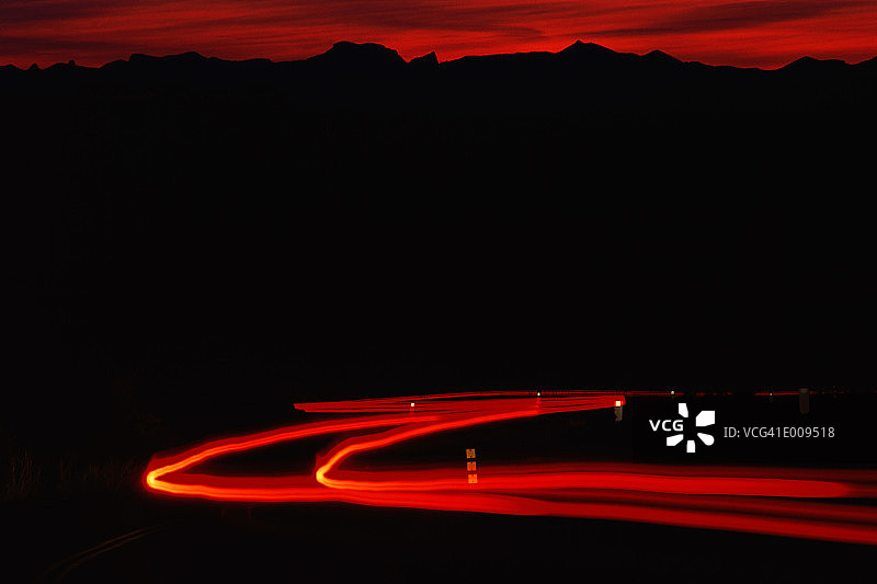 日落时分，山影前的模糊尾灯图片素材