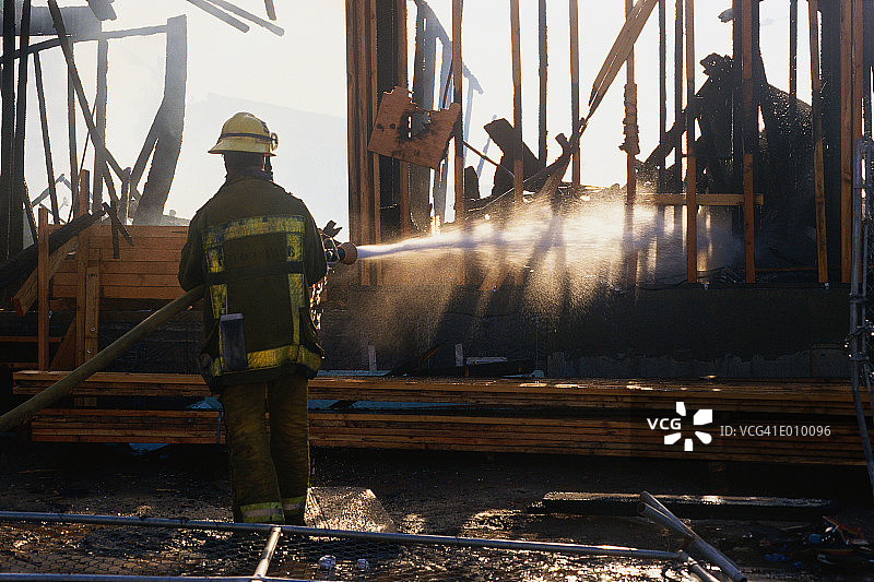 消防员用水管喷淋建筑物图片素材