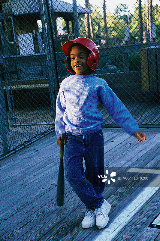 戴棒球头盔的非洲裔美国男孩手持球棒图片素材