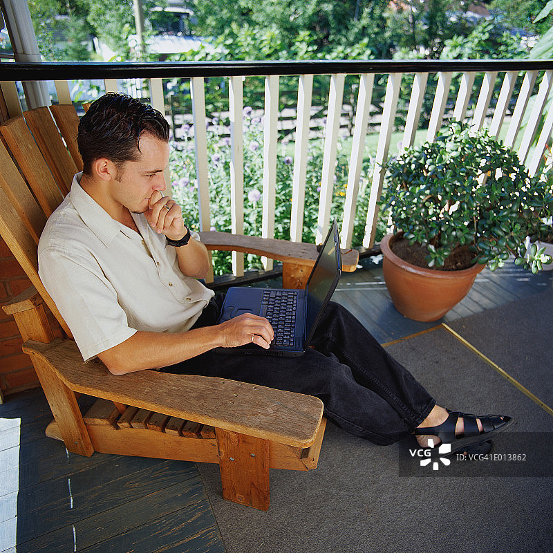 男人在门廊上使用电脑图片素材