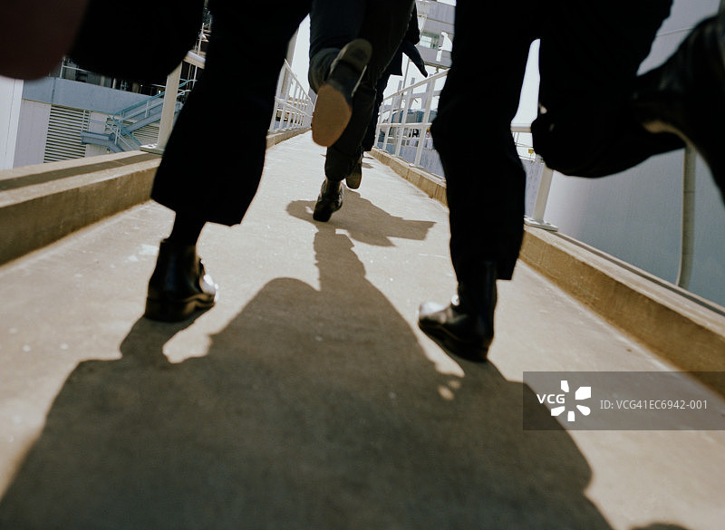 在走道上奔跑的黑西装男人们（低角度）图片素材