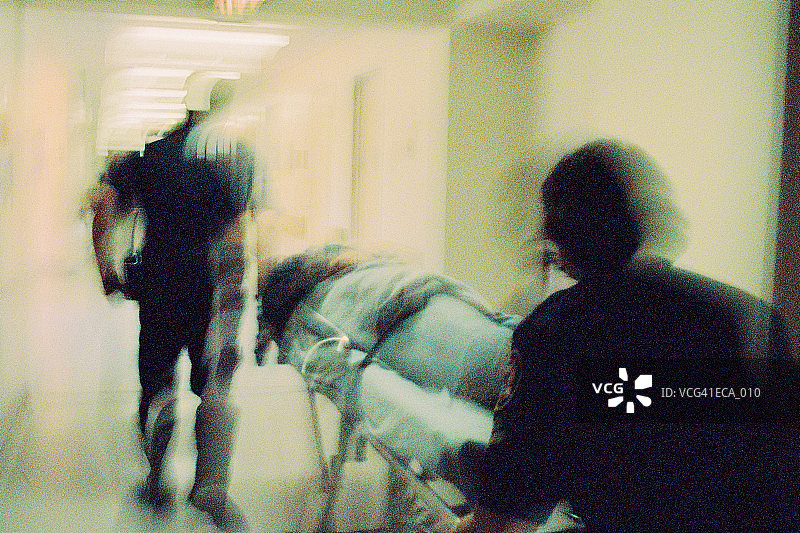 两名护理人员在医院走廊里推动担架图片素材