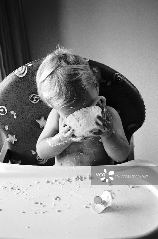 坐在高脚椅上吃饭的宝宝图片素材