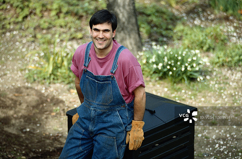 男人坐在垃圾箱上图片素材