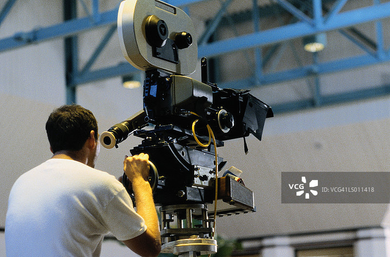 操作电影摄像机的摄像师（后视图）图片素材