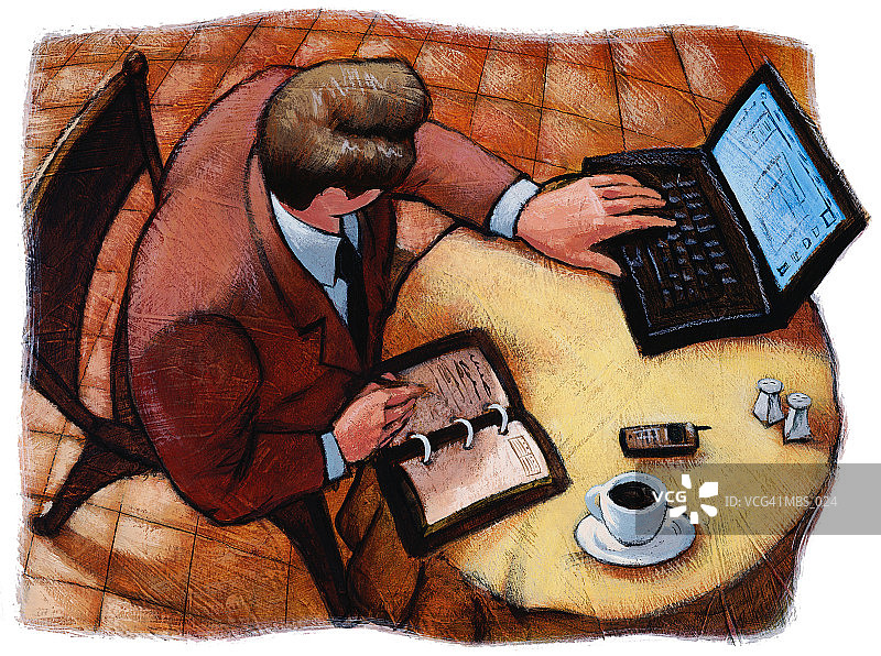 男人坐在餐厅的桌子旁，使用笔记本电脑图片素材