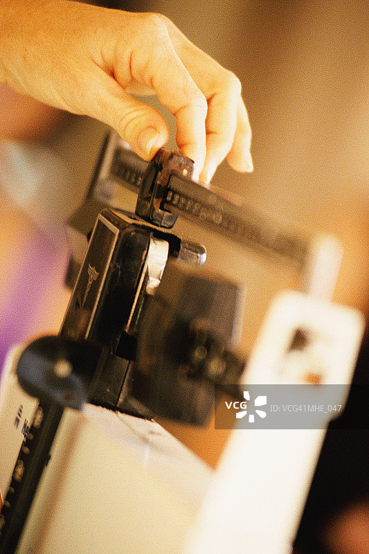 在秤上移动砝码的手图片素材