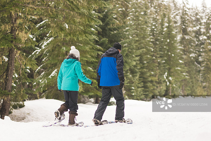 老年夫妇在森林里踩雪鞋图片素材
