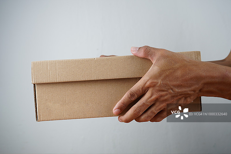 身穿白衬衫的快递员在影棚拍摄中送货箱图片素材