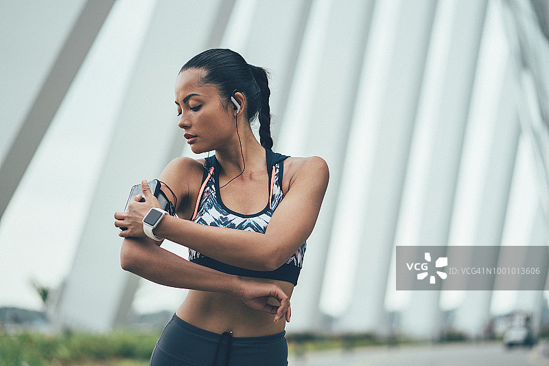 女运动员查看臂带图片素材