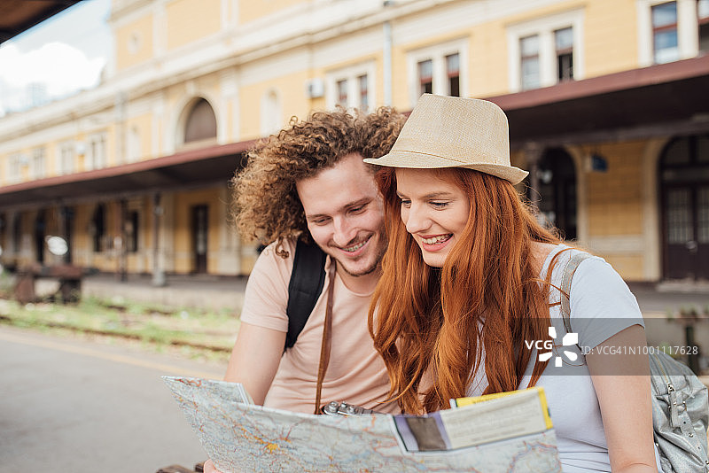 年轻夫妇在火车站看地图图片素材