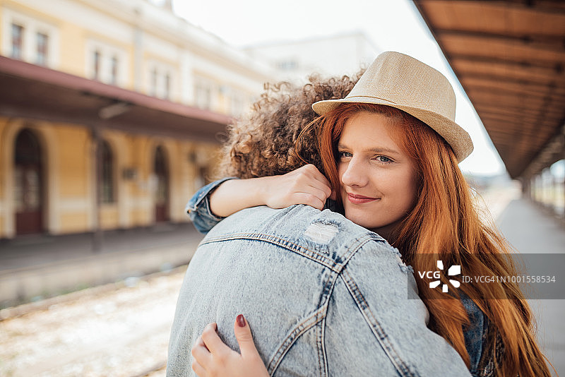 在火车站拥抱男友告别的红发女孩图片素材