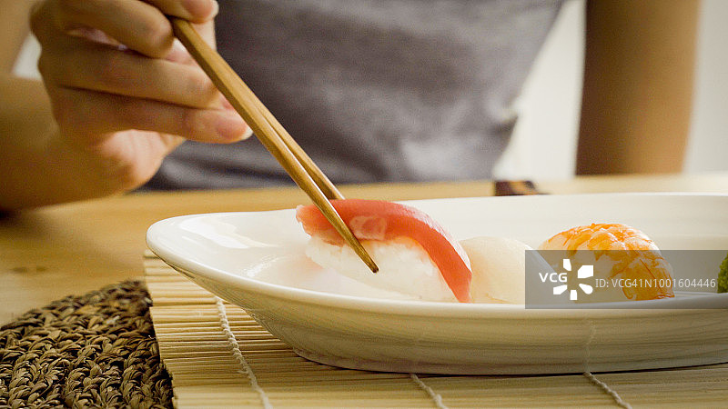 女人在吃寿司，蘸酱油和芥末图片素材