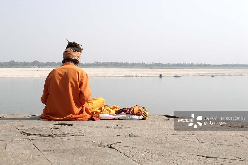印度北方邦瓦拉纳西圣河恒河岸边，身穿橙色服装的印度教苦行僧（僧侣）图片素材