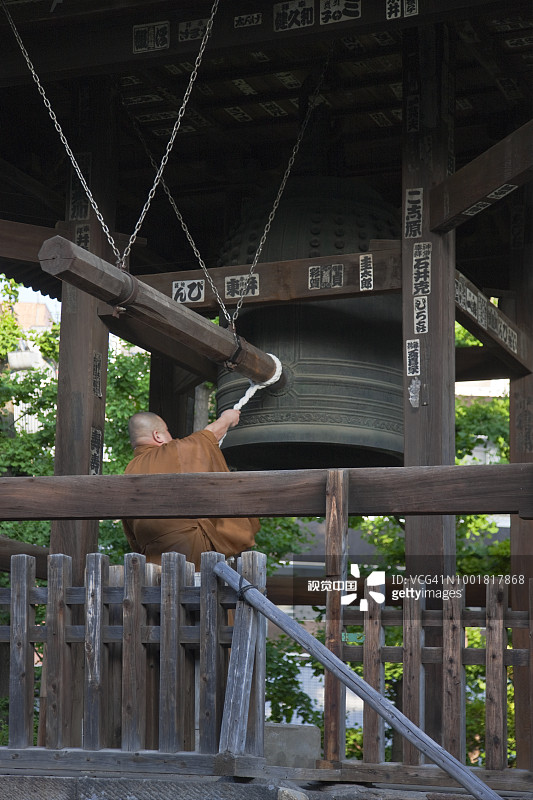 日本东京浅草区，僧人在浅草寺敲钟图片素材