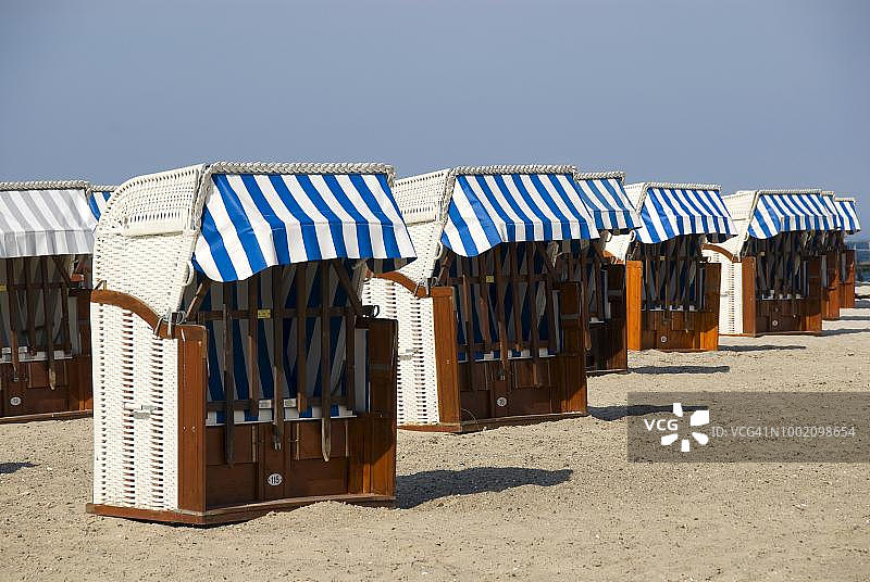 德国石勒苏益格-荷尔斯泰因州特拉弗明德海滩的空顶棚柳条沙滩椅（淡季）图片素材