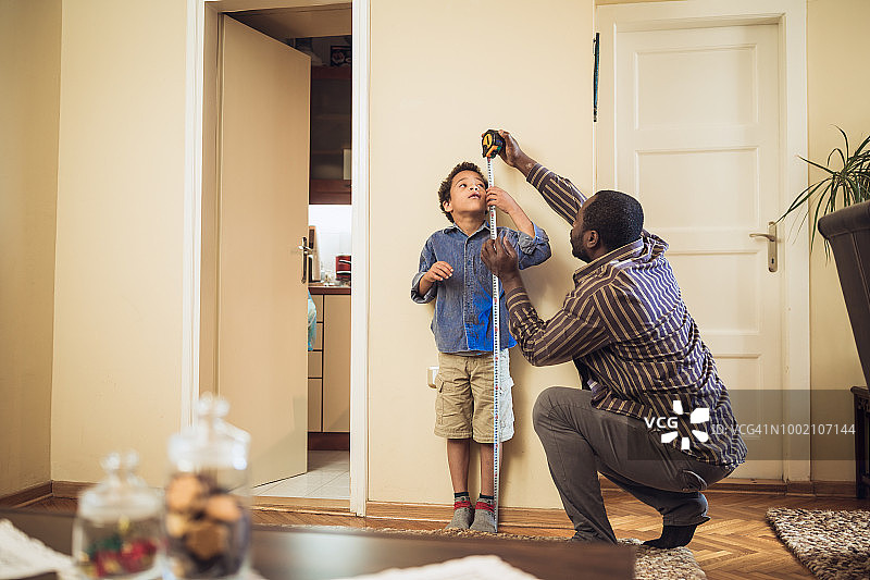 父亲测量儿子的身高图片素材