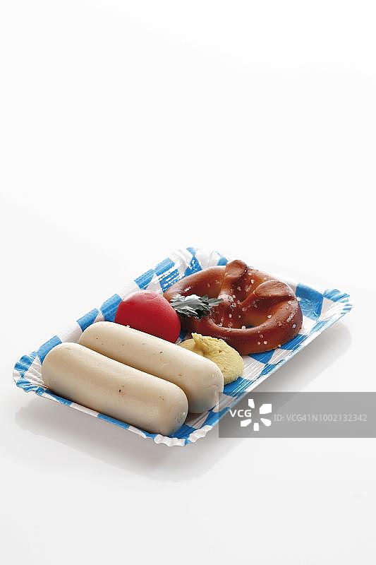 巴伐利亚纸盘小吃：椒盐卷饼、巴伐利亚小牛肉香肠、萝卜和芥末杏仁糖图片素材