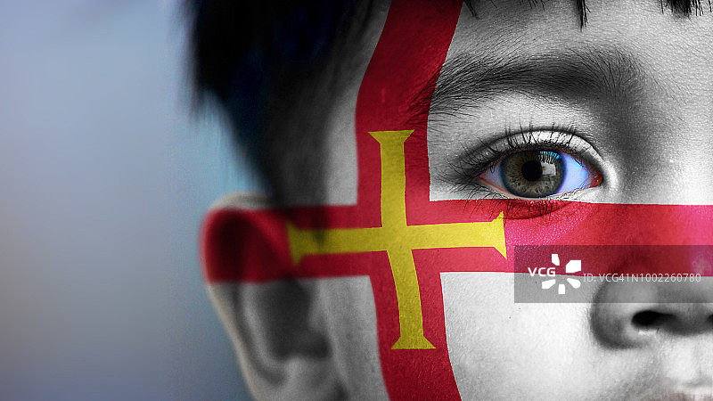 脸上带有数字合成的根西岛旗帜的男孩图片素材